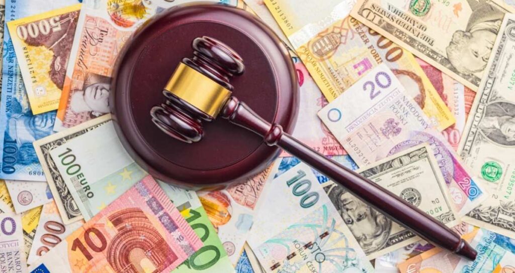 martello del giudice su un tappeto di soldi a simboleggiare i rischi legali dei paradisi fiscali